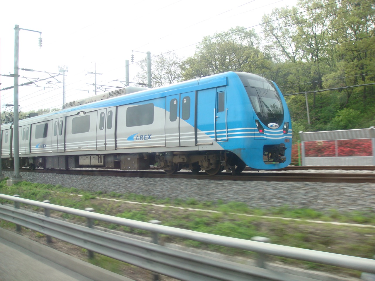 Blue AREX airport railroad train traveling on elevated tracks near Seoul