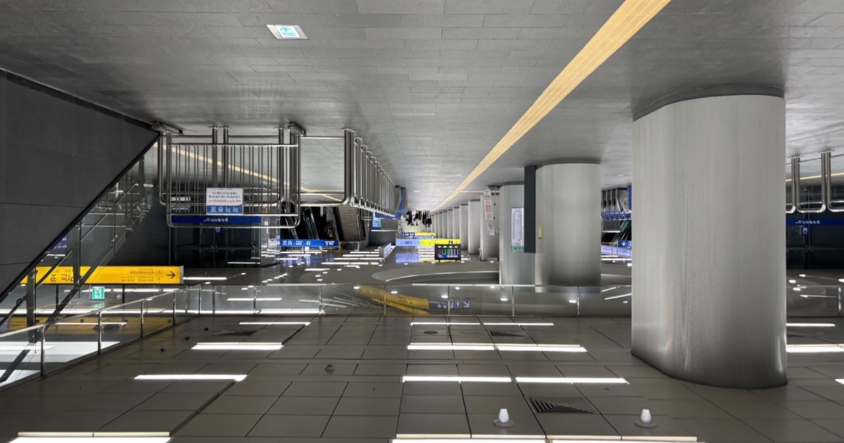 Hongik University Station concourse with overhead wayfinding signs