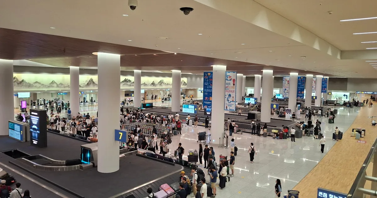 Travelers collecting luggage in the Terminal 2 arrival hall at Incheon International Airport